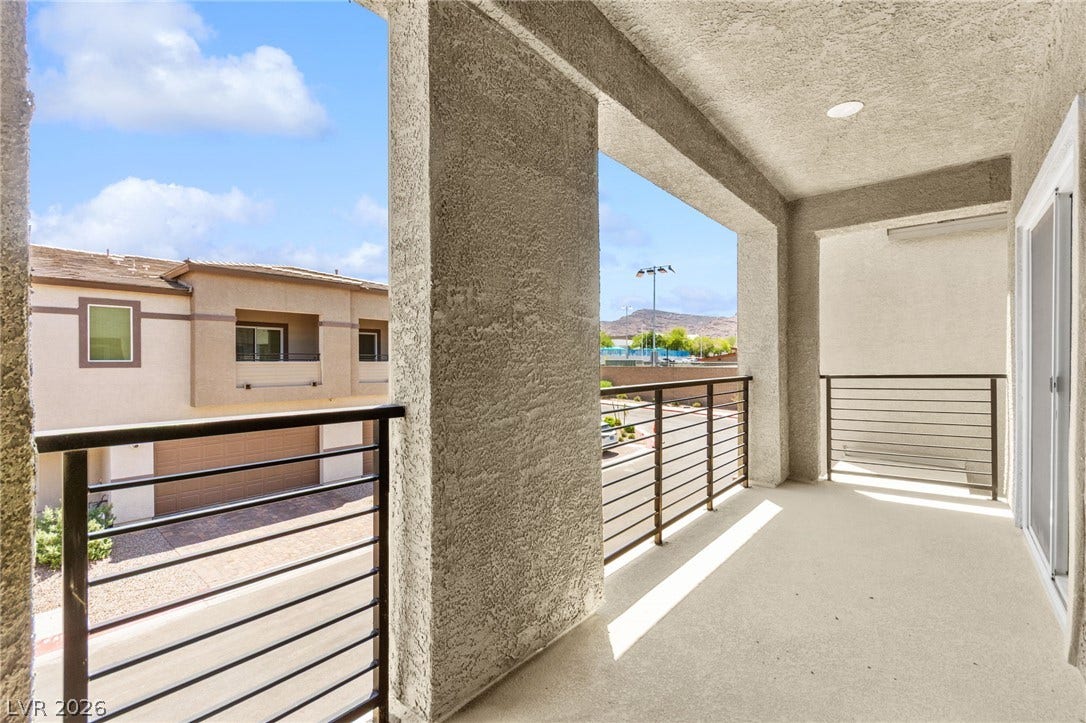 An inviting private balcony, framed by sturdy railings, offers clear views of the distant mountains.