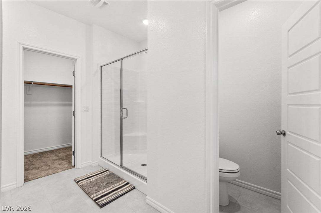 A well-appointed bath features a spacious walk-in shower and ample closet space.