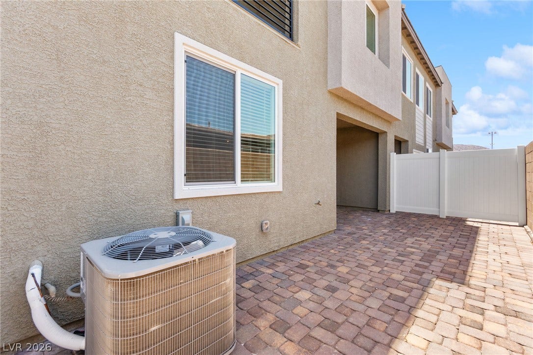 An inviting paver-laid driveway and sturdy fencing enhance the home's practical exterior.
