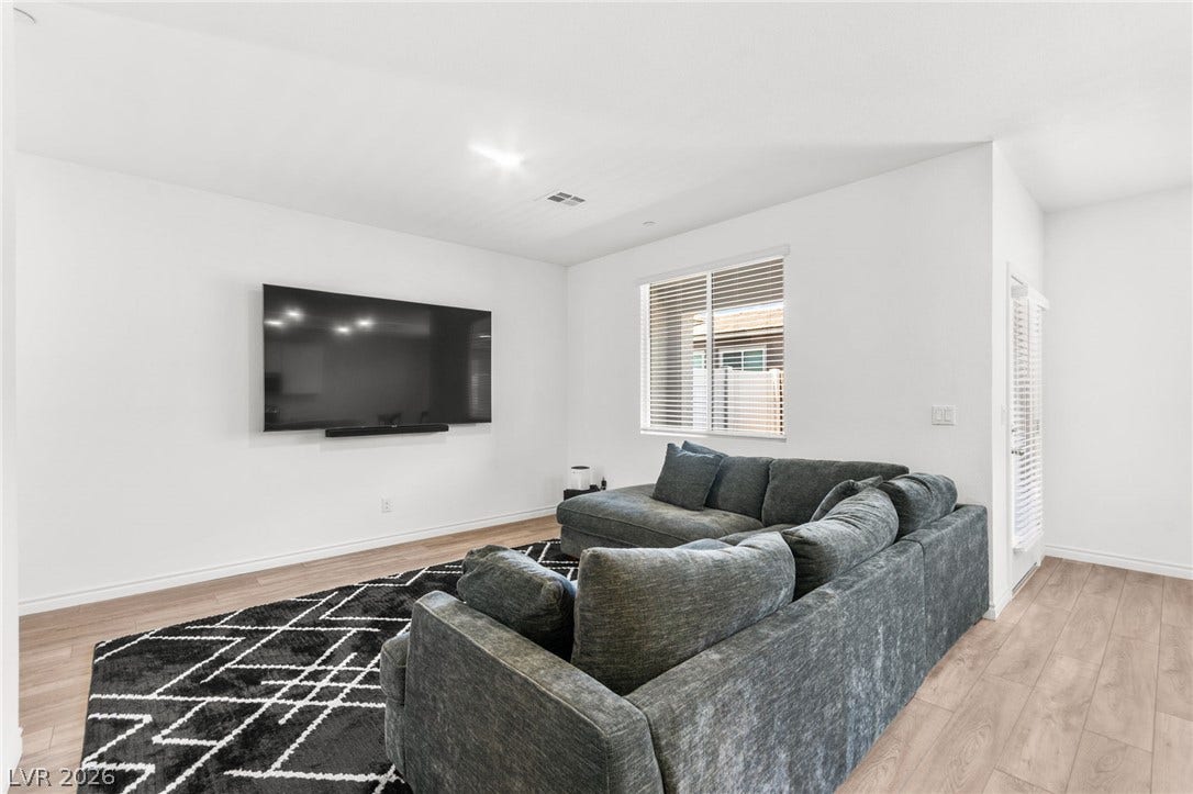 A well-lit living area showcases light hardwood-style flooring and a spacious layout perfect for relaxation.