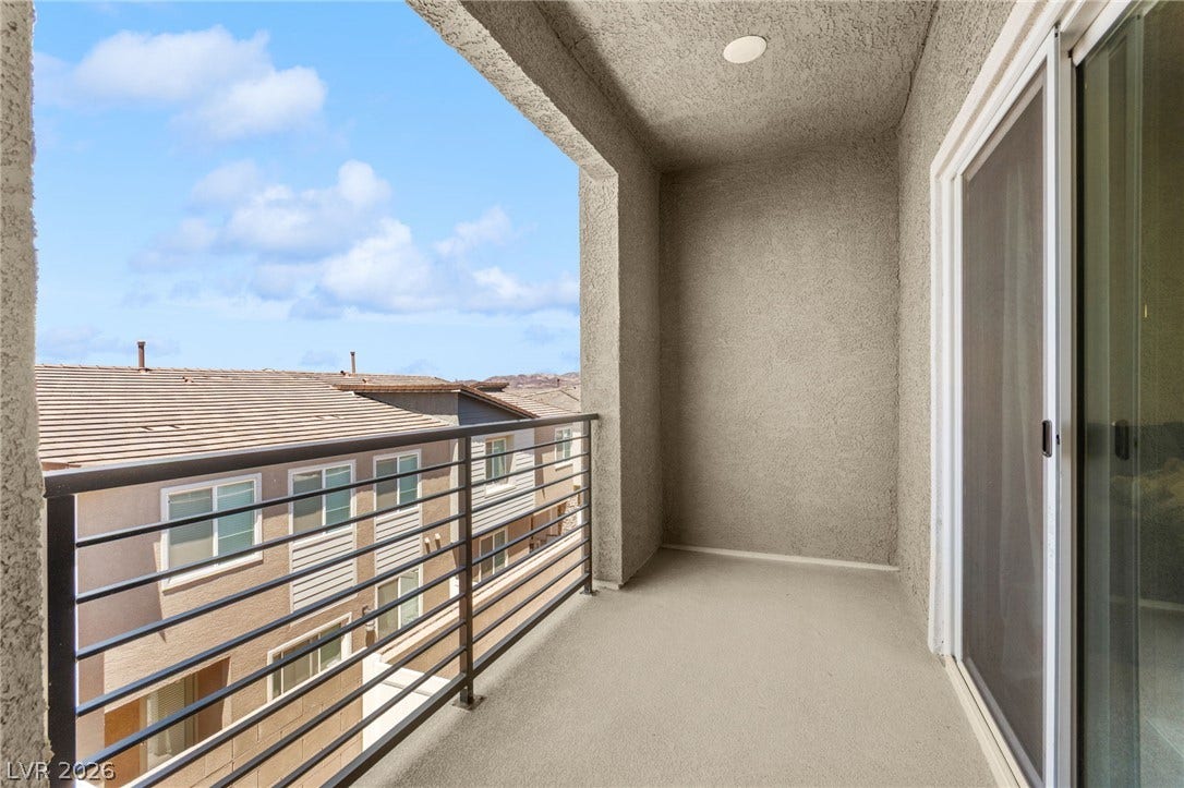 A private balcony offers serene views of neighborhood rooftops and distant hills.