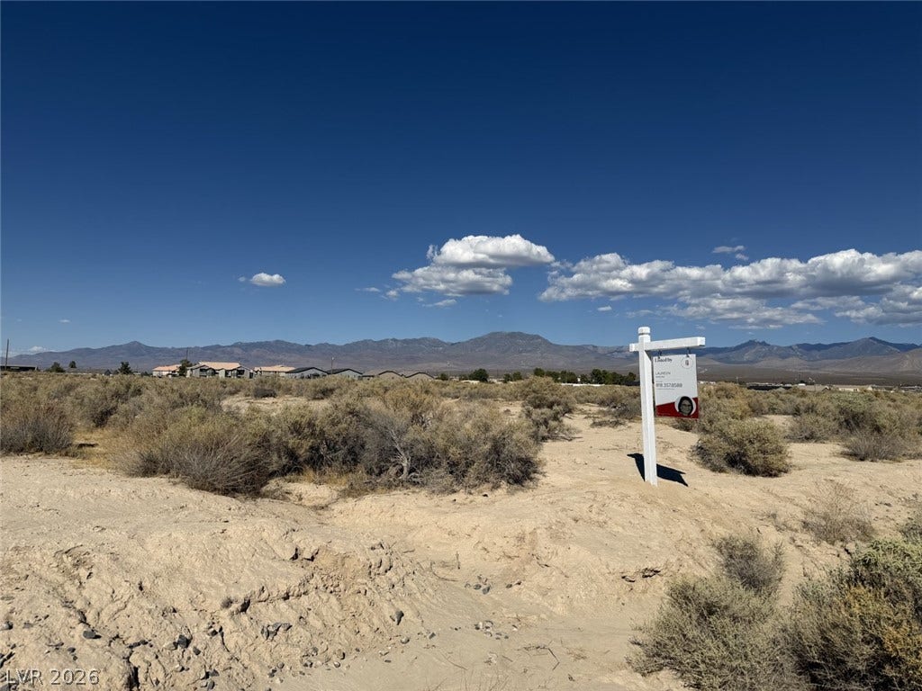 1870 Elko Street, Pahrump, NV 89048 A vacant desert parcel offers majestic mountain views under a vast blue sky.