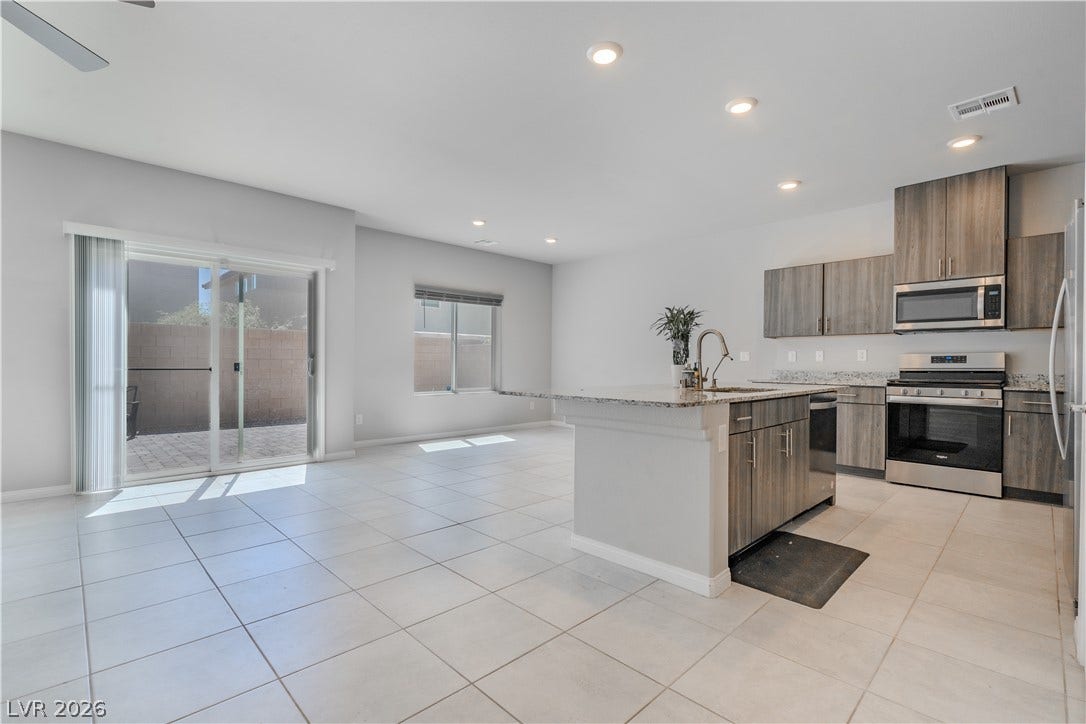 8920 Seal Cove Street, Las Vegas, NV 89178 Clean tile flooring flows through the open-concept kitchen into a sunlit dining area.