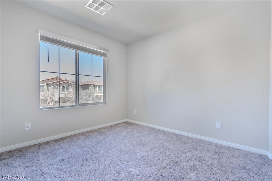8920 Seal Cove Street, Las Vegas, NV 89178 Plush carpeting and a large window defining this versatile secondary bedroom space.