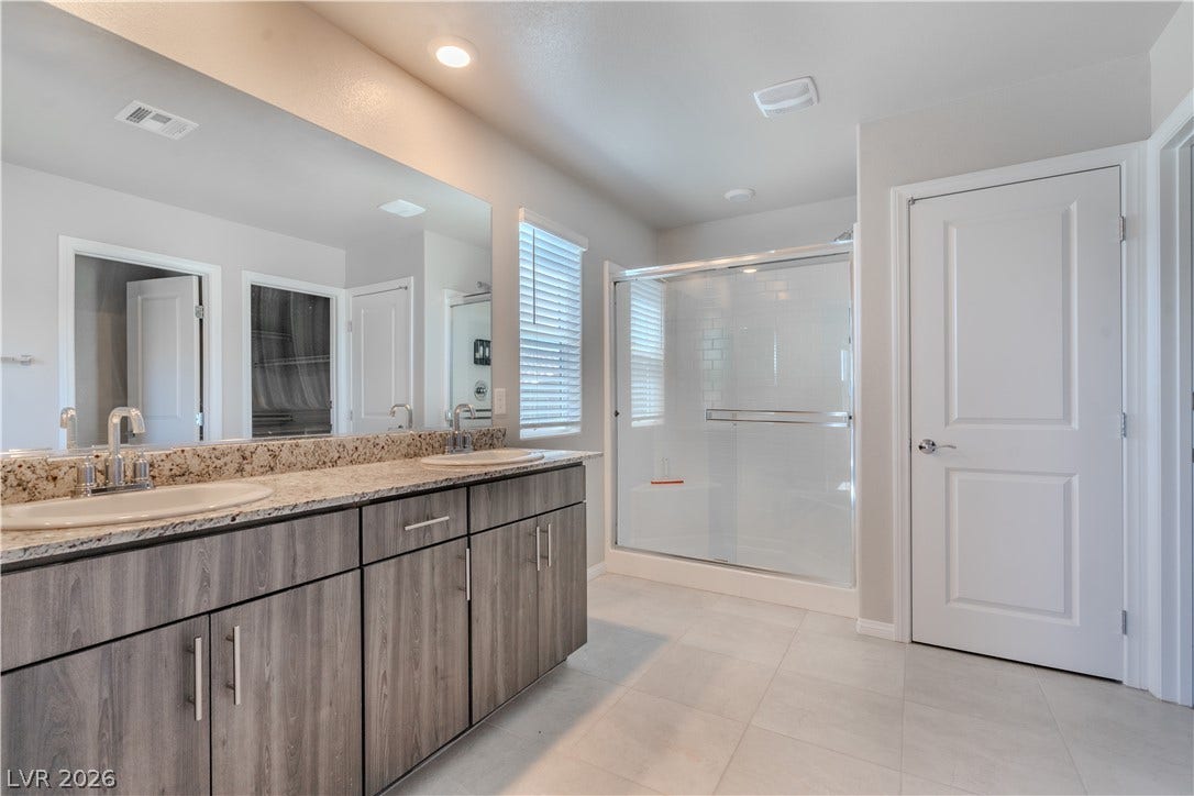8920 Seal Cove Street, Las Vegas, NV 89178 Granite counters and dual sinks complement the contemporary design of this primary bath.