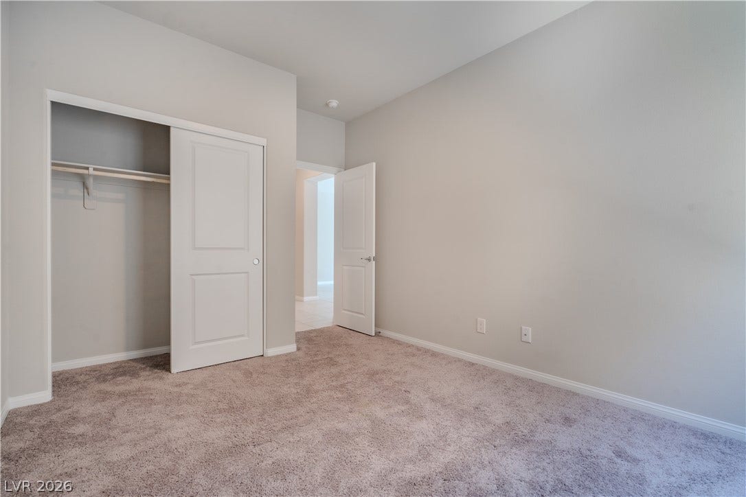8920 Seal Cove Street, Las Vegas, NV 89178 Plush carpeting and a built-in closet define this versatile secondary bedroom space.