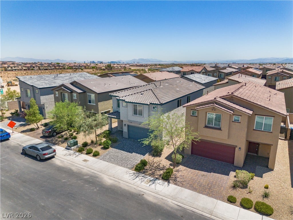 8920 Seal Cove Street, Las Vegas, NV 89178 A quiet residential street lined with modern multi-level homes under a clear blue sky.