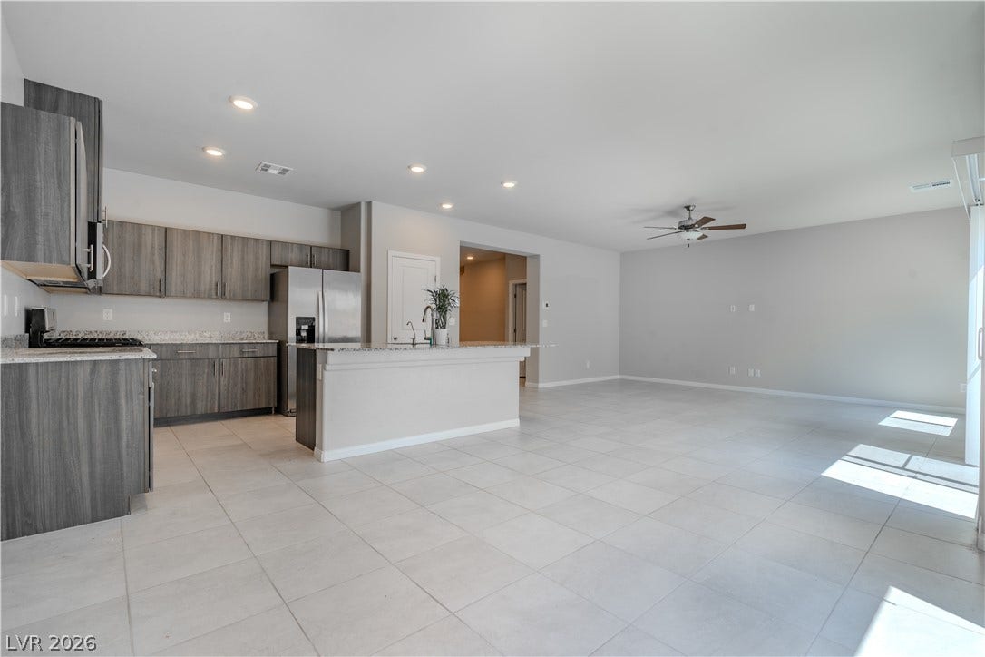 8920 Seal Cove Street, Las Vegas, NV 89178 Gleaming tile floors stretch across a light-filled kitchen and open dining area.