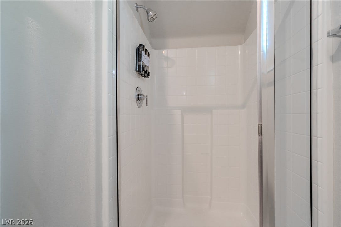 8920 Seal Cove Street, Las Vegas, NV 89178 **Downstairs bathroom**
Clean lines and classic white tile define this walk-in shower enclosure.