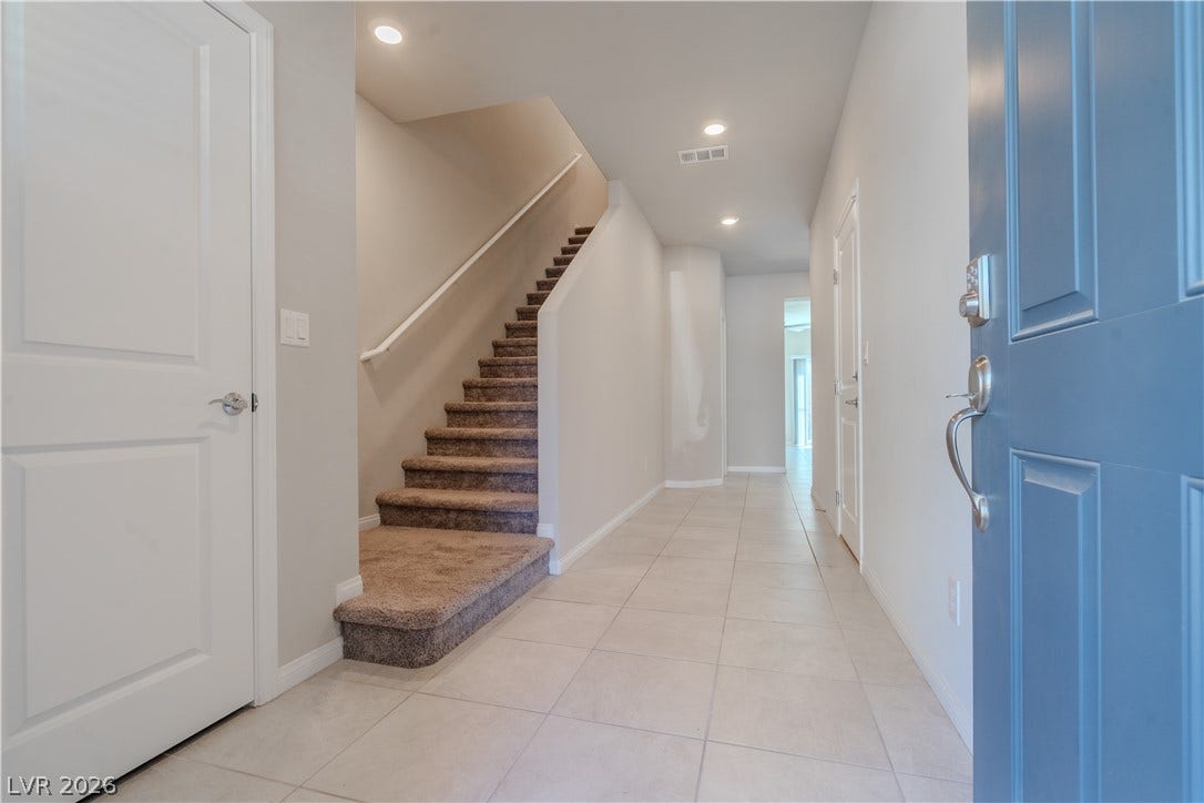 8920 Seal Cove Street, Las Vegas, NV 89178 A welcoming entryway features tile flooring and a carpeted staircase leading to the upper level.