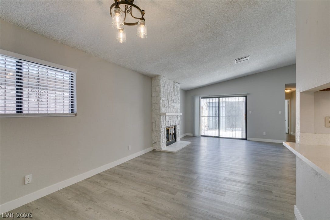 A striking stone fireplace and vaulted ceilings define this inviting living area.