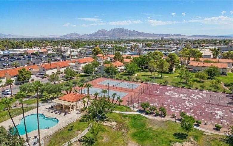 Overlooking the vibrant community, discover a refreshing pool, tennis courts, and recreational amenities with a scenic mountain backdrop.
