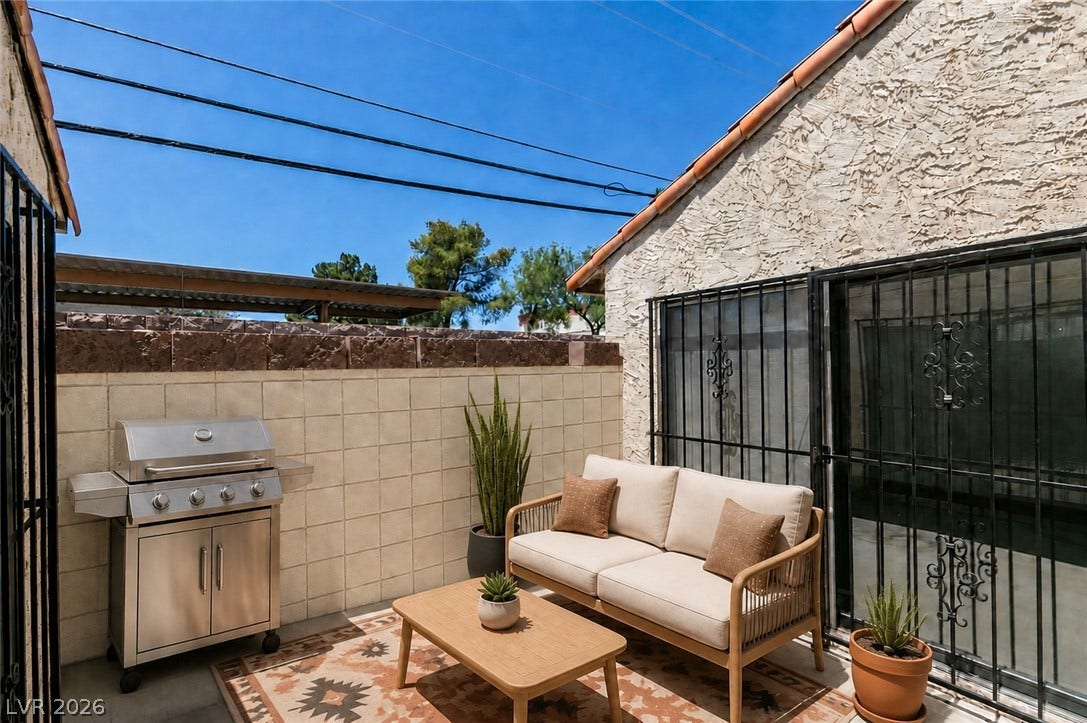 An enclosed concrete patio with block walls offers a private outdoor retreat.