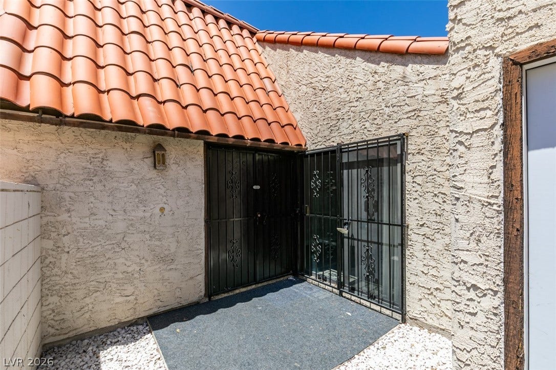 A terracotta tile roof accents this exterior entry with ornamental security gates, offering both charm and protection.