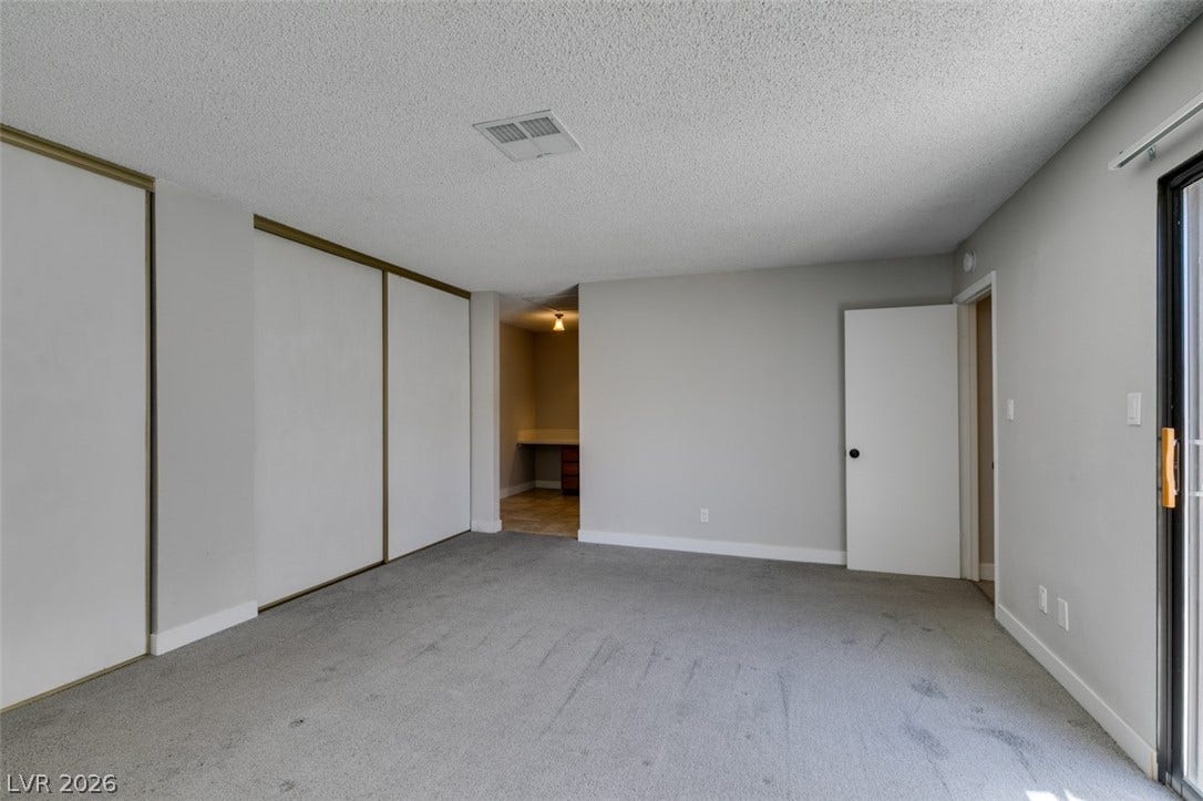 Ample closet space complements this versatile room, perfect for a bedroom or home office.