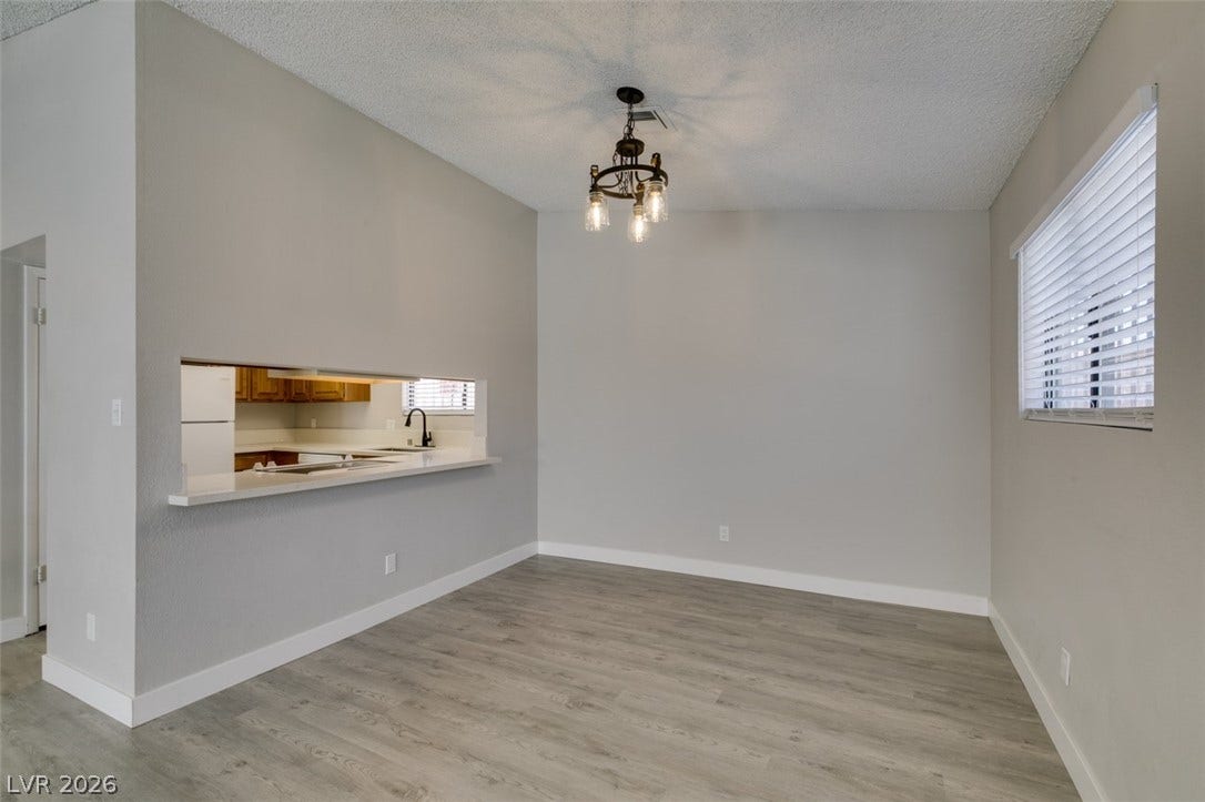 A versatile open-plan area offers seamless flow from the kitchen to dining space, illuminated by an elegant chandelier.