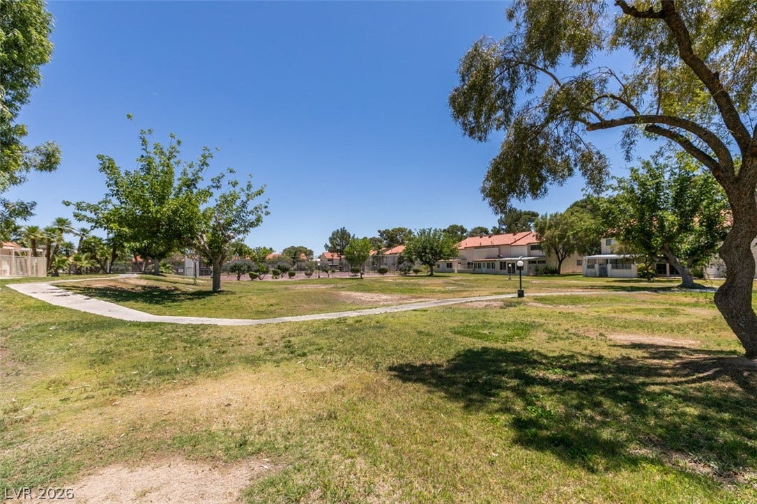 A winding pathway guides through open green spaces, connecting residences and community recreation.
