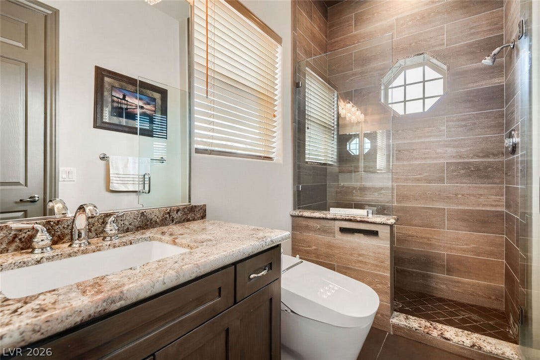 2010 Shenley Court, Las Vegas, NV 89117 Rich wood-look tile highlights a walk-in shower alongside granite vanity tops.