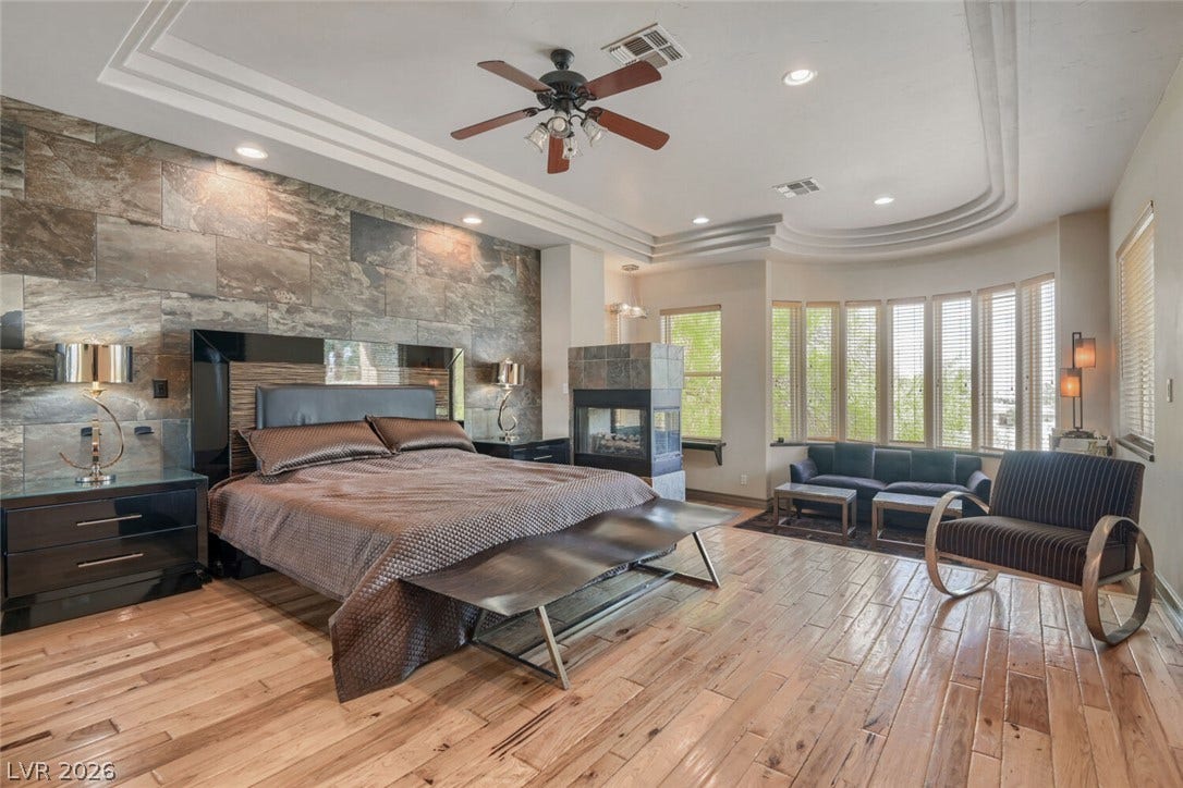 2010 Shenley Court, Las Vegas, NV 89117 Polished wood floors and a custom stone feature wall define this main bedroom retreat.