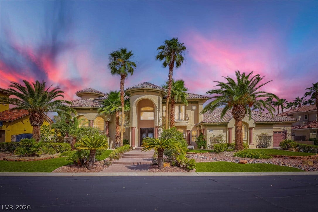 2010 Shenley Court, Las Vegas, NV 89117 Palm trees flank the grand entryway of this elegant desert estate beneath a vibrant twilight sky.