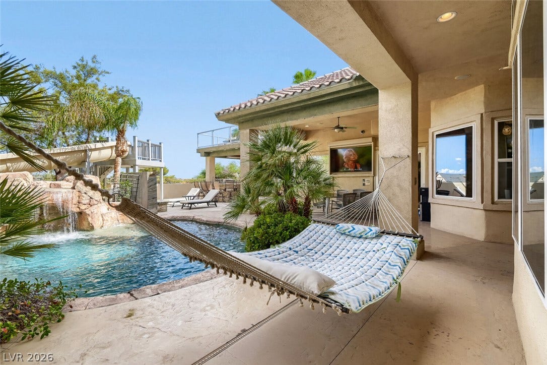 2010 Shenley Court, Las Vegas, NV 89117 A shaded patio opens directly to a resort-style pool with a rock waterfall.