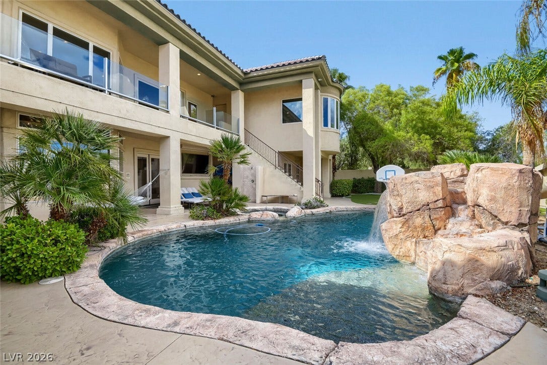 2010 Shenley Court, Las Vegas, NV 89117 A custom rock waterfall cascades into the sparkling pool behind this multi-level Mediterranean estate.