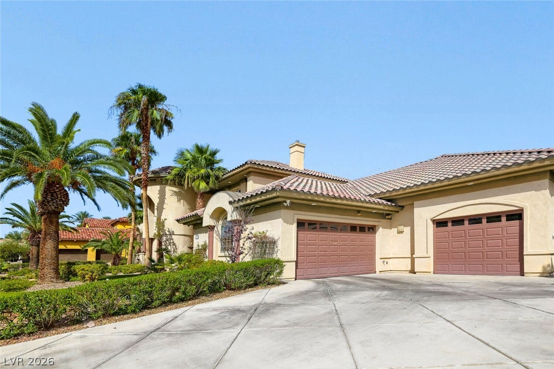 2010 Shenley Court, Las Vegas, NV 89117 An expansive concrete driveway leads to a stucco exterior featuring classic tile roofing.