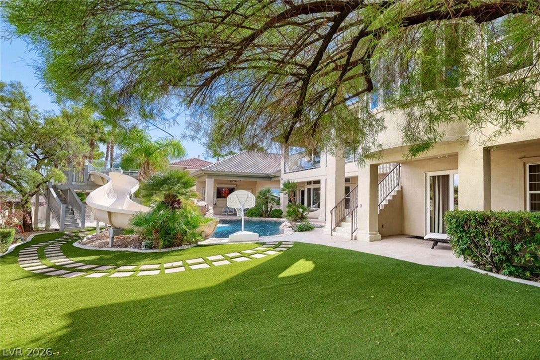 2010 Shenley Court, Las Vegas, NV 89117 Lush manicured turf leads to a private resort-style pool with an integrated water slide.