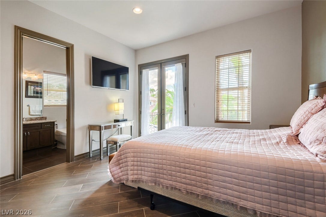 2010 Shenley Court, Las Vegas, NV 89117 French doors open to outdoor views, highlighting wood-look tile flooring in this serene bedroom.