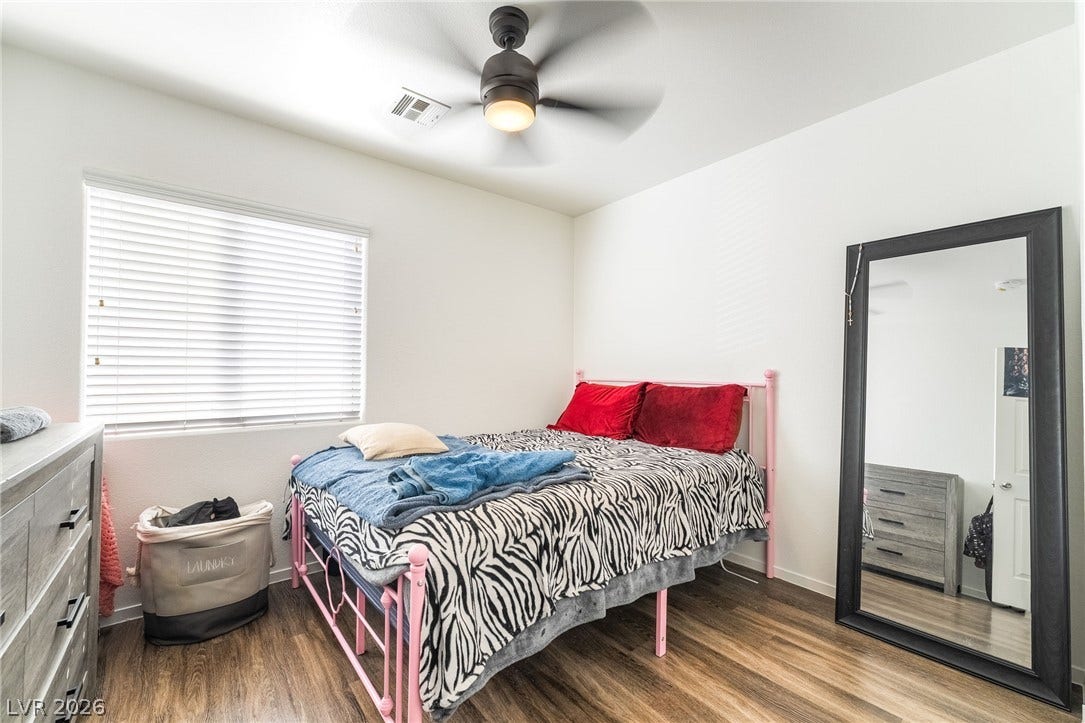 6275 Felicitas Avenue, Las Vegas, NV 89122 Rich wood-inspired floors and a wide window create a comfortable, inviting atmosphere.