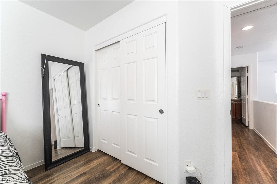 6275 Felicitas Avenue, Las Vegas, NV 89122 Rich wood-inspired flooring complements clean white walls in this functional bedroom layout.