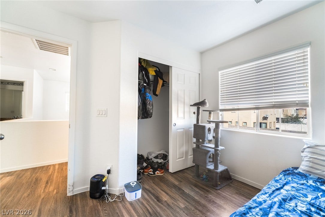 6275 Felicitas Avenue, Las Vegas, NV 89122 Rich wood-inspired flooring and a wide window with integrated blinds define this versatile bedroom.