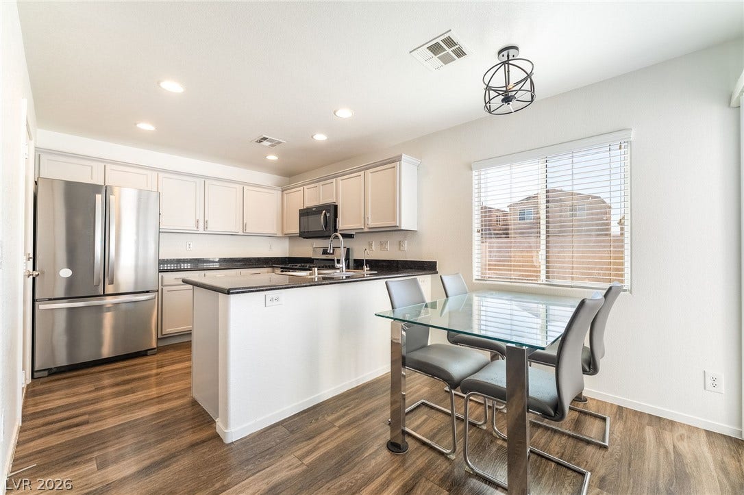 6275 Felicitas Avenue, Las Vegas, NV 89122 Rich wood flooring anchors this culinary space equipped with dark countertops and modern cabinetry.