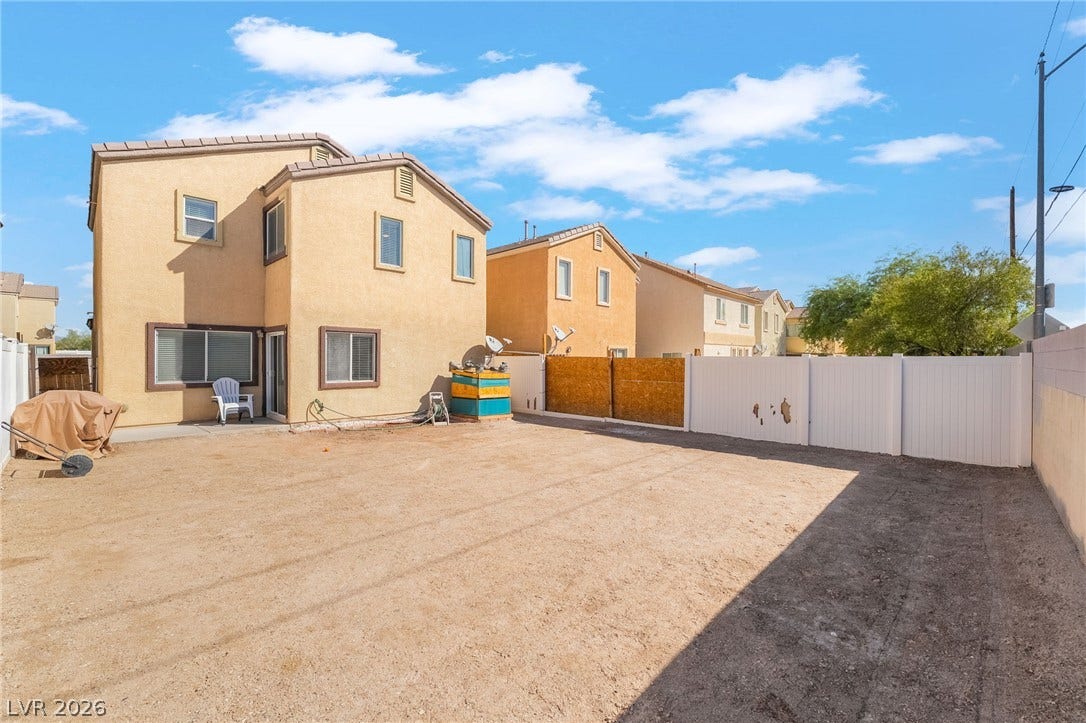 6275 Felicitas Avenue, Las Vegas, NV 89122 An enclosed backyard space features a low-maintenance dirt yard and stucco exterior walls.