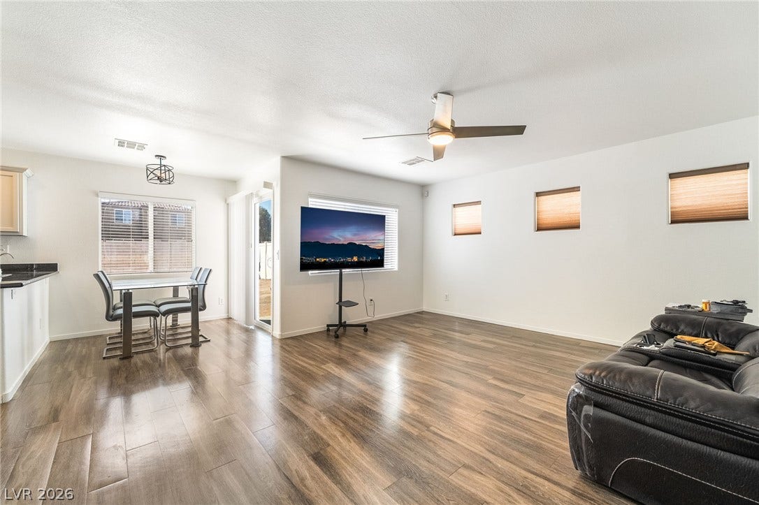 6275 Felicitas Avenue, Las Vegas, NV 89122 Polished wood floors stretch across a versatile open-plan layout under clean neutral walls.