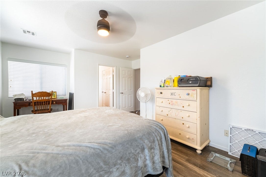 6275 Felicitas Avenue, Las Vegas, NV 89122 Smooth wood-look flooring and clean white walls define this airy, comfortable bedroom space.