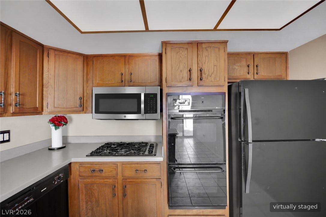 3753 Heritage Avenue, Las Vegas, NV 89121 Rich wood cabinetry surrounds integrated cooking appliances in this functional kitchen layout.