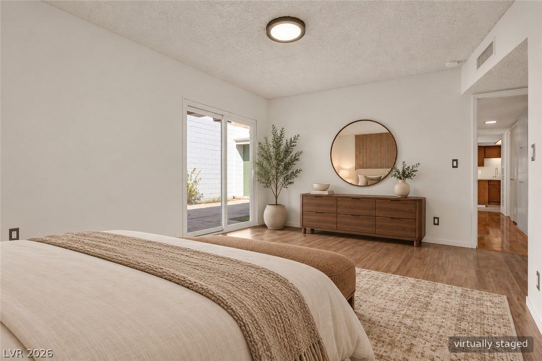 3753 Heritage Avenue, Las Vegas, NV 89121 Sliding glass doors open to the outdoors from this bedroom with wood floors.
