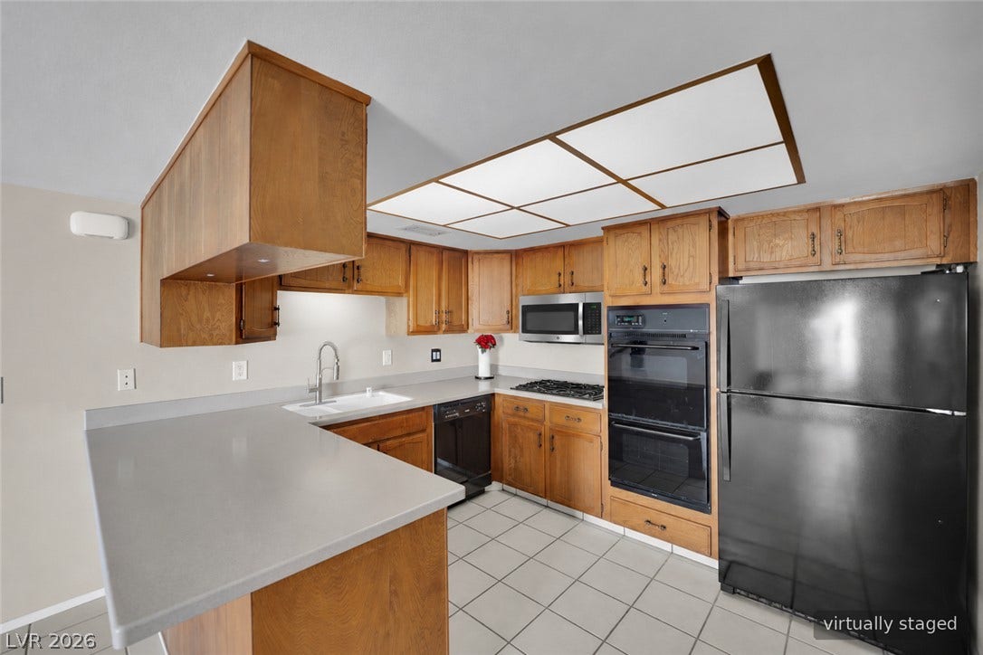 3753 Heritage Avenue, Las Vegas, NV 89121 Functional kitchen design showcases abundant wood cabinetry alongside streamlined solid-surface countertops.