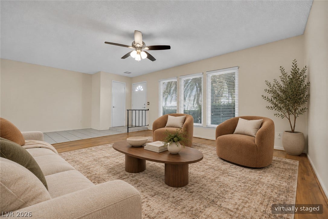 3753 Heritage Avenue, Las Vegas, NV 89121 Sunlight streams through triple windows onto warm wood flooring in this comfortable main living space.