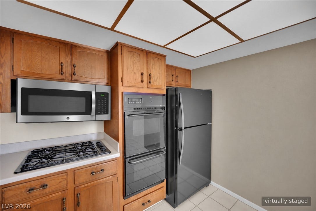 3753 Heritage Avenue, Las Vegas, NV 89121 Rich wood cabinetry surrounds integrated cooking appliances in this functional kitchen layout.