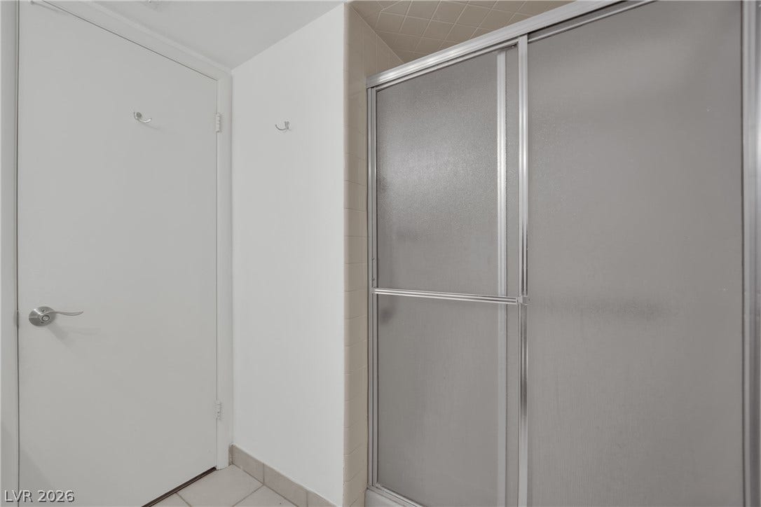 3753 Heritage Avenue, Las Vegas, NV 89121 A frosted glass shower enclosure stands alongside tiled flooring in this bathroom.