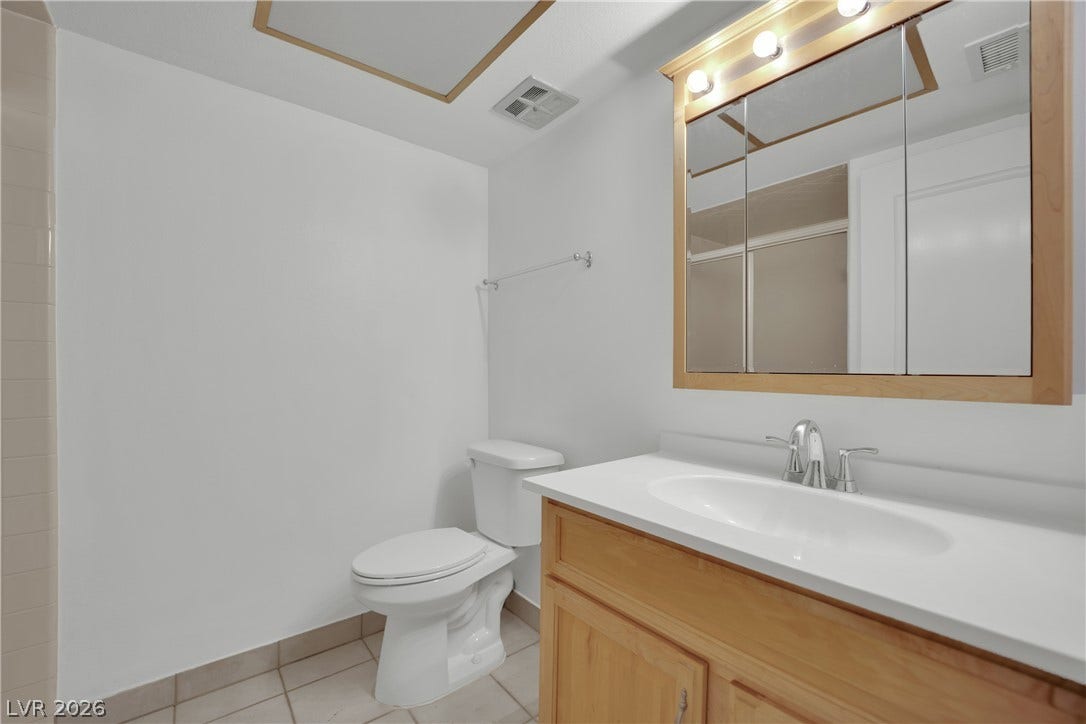 3753 Heritage Avenue, Las Vegas, NV 89121 Functional layout highlights this clean washroom featuring a wood vanity and neutral tile flooring.