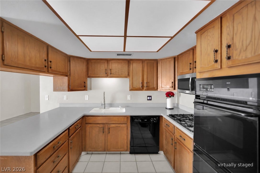 3753 Heritage Avenue, Las Vegas, NV 89121 Ample wooden cabinetry and clean countertops define this functional U-shaped kitchen layout.