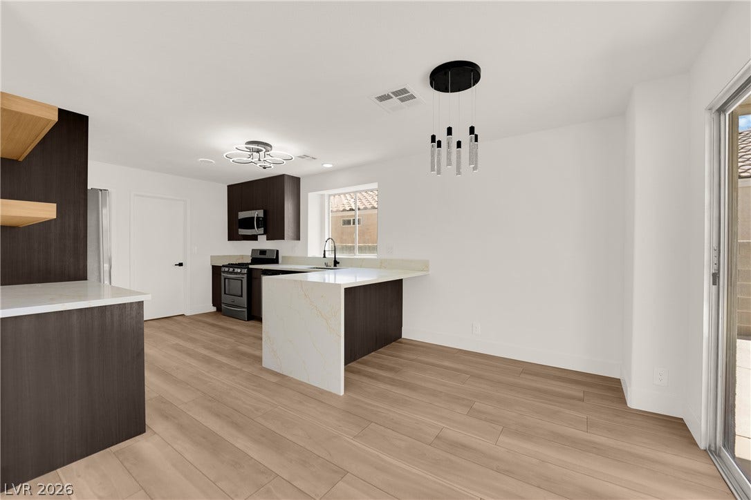 Gleaming wood-look floors anchor this airy open concept kitchen and dining space.