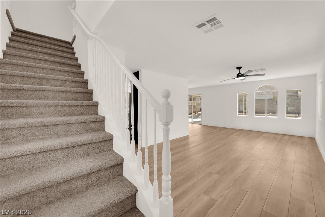 Plank flooring and a carpeted staircase anchor this open main level layout.