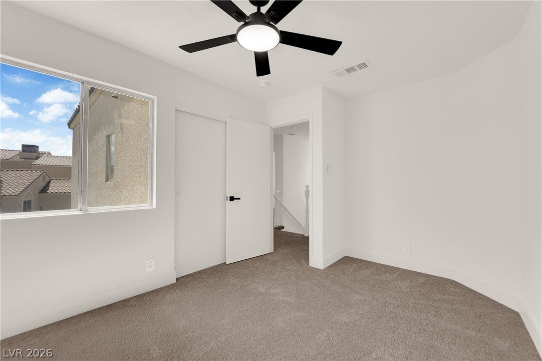 Plush carpeting and an abundance of natural light highlight this modern bedroom layout.