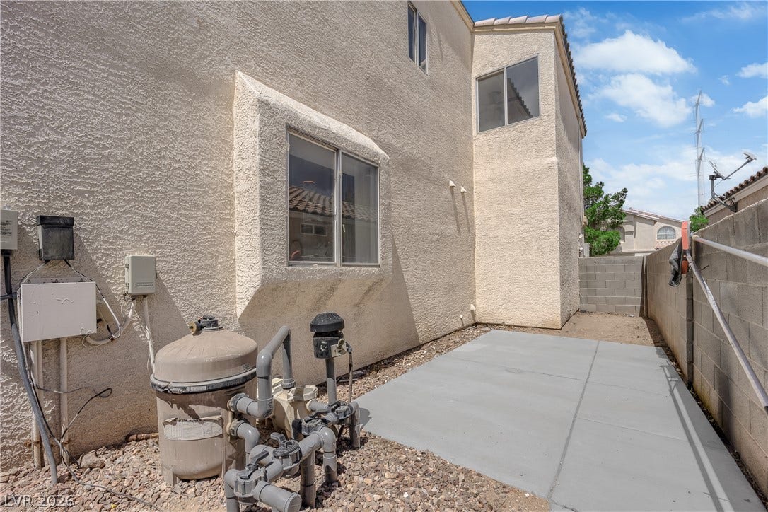 Stucco exterior walls and a concrete pad define the functional side yard space.