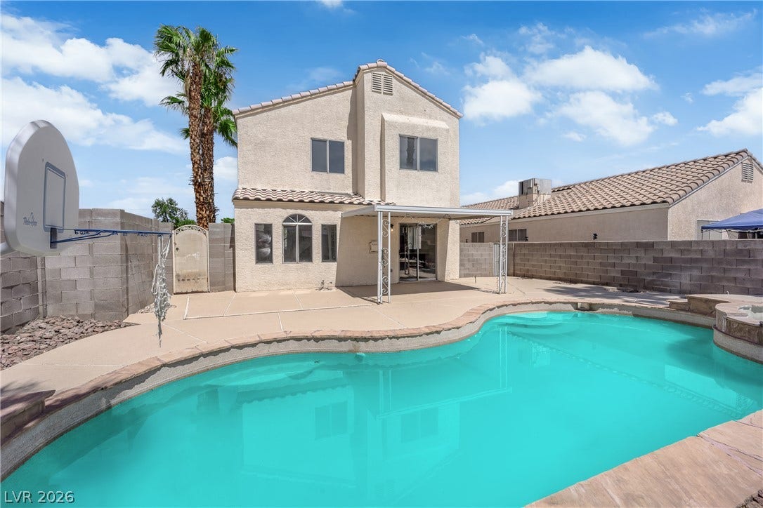 An inviting swimming pool anchors this private backyard setting complete with a covered patio.