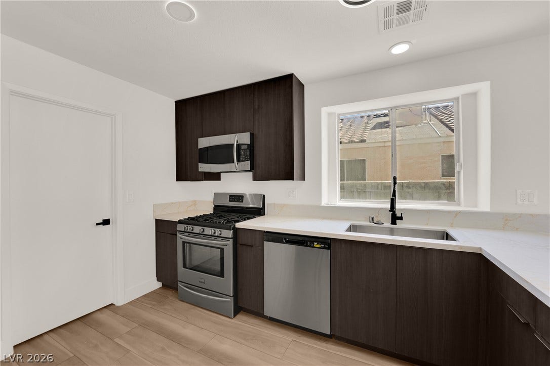 Sleek modern cabinetry and durable stone counters define this functional culinary space.